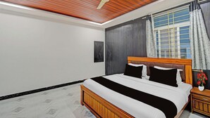 Un dormitorio con cama, mesita de noche, ventilador de techo, ventana con cortinas y aire acondicionado de pared.