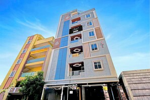 A multi-story building with a mix of architectural styles, including a yellow facade and a grey upper section with large windows. - Super Collection O Gachibowli Phase 2 (Hyderabad)