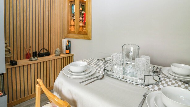 A dining area with a checkered tablecloth, white plates, and clear glassware. - 6 Niddrie Marischal Road (Edinburgh)