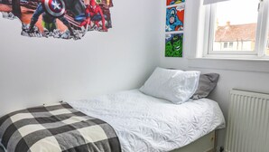 A bedroom with a single bed, a radiator, and a window with a view of buildings. - 6 Niddrie Marischal Road (Edinburgh)