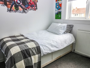 A bedroom with a single bed, a radiator, and a window with a view of buildings. - 6 Niddrie Marischal Road (Edinburgh)