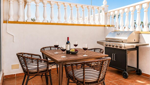 An outdoor patio with a table set for dining, a grill, and wicker chairs. - Pet friendly home in Torrevieja with WiFi (Torrevieja)
