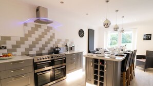 Una cocina moderna con una isla central, hornos empotrados y un amplio ventanal que proporciona luz natural.