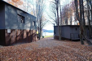 A modern building with a gravel driveway and leaf-covered ground.