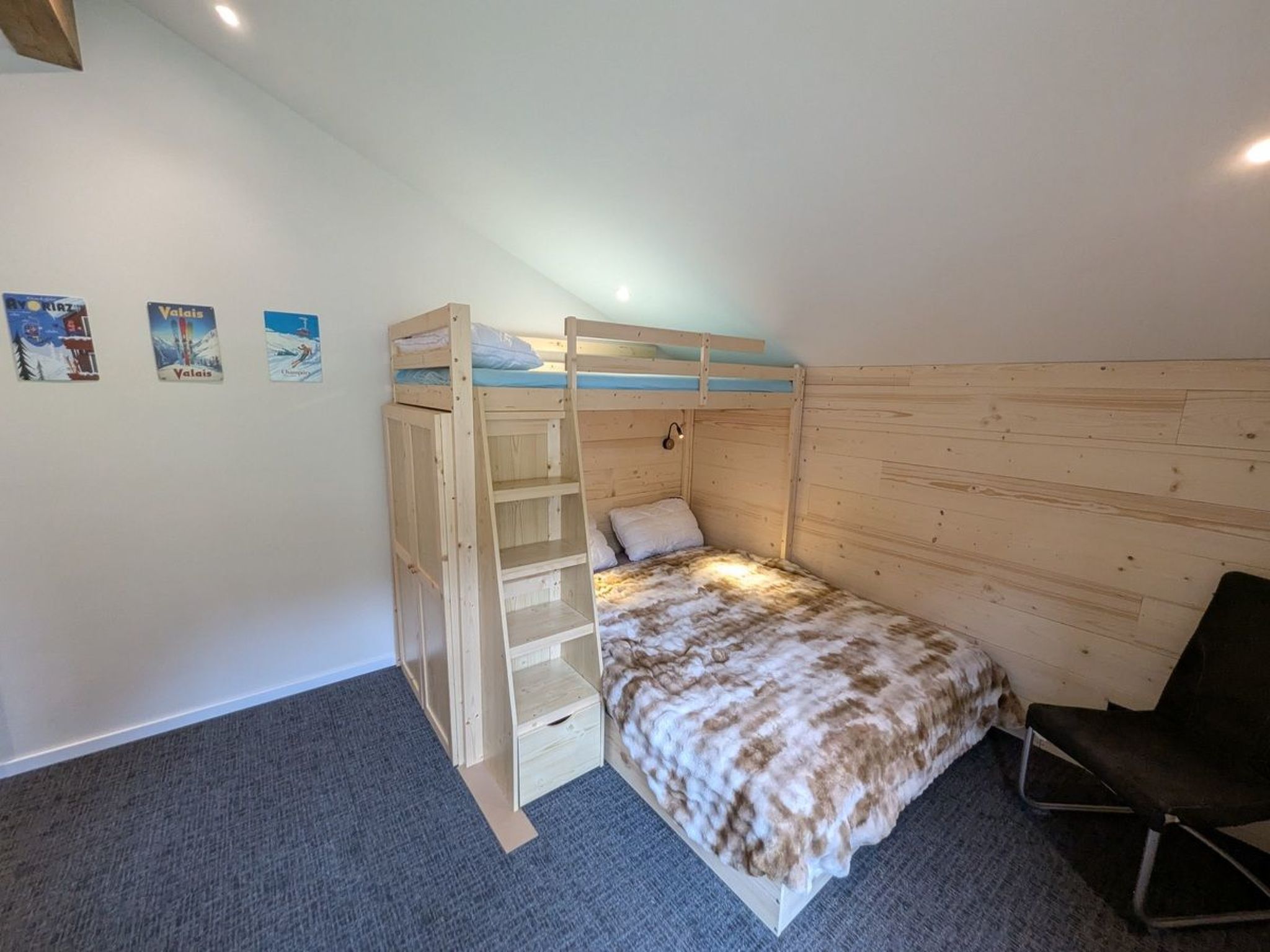 A single bunk bed room with a wooden headboard, a small desk, and a chair.