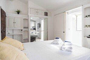 A hotel room with a bed, a desk, a chair, a small kitchenette, and a bathroom. - A/C studio in the heart of Cannes – Old Port (Cannes)