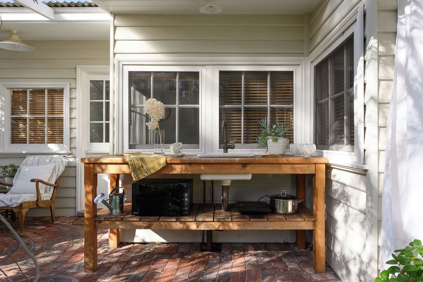 A kitchen area with a wooden table, a chair, and a potted plant.