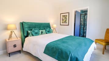 A bedroom with a bed, nightstands, a chair, and a door.