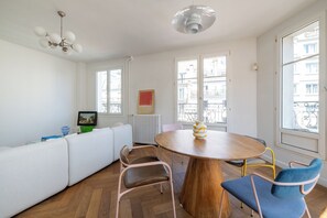 Ein modernes Wohnzimmer mit einem runden Holztisch, einer Couch und einem Essbereich.