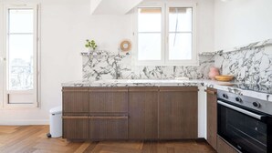 A kitchen with a marble countertop, wooden cabinets, and a built-in oven. - Bright and Spacious 1BDR in Central Paris (Paris)