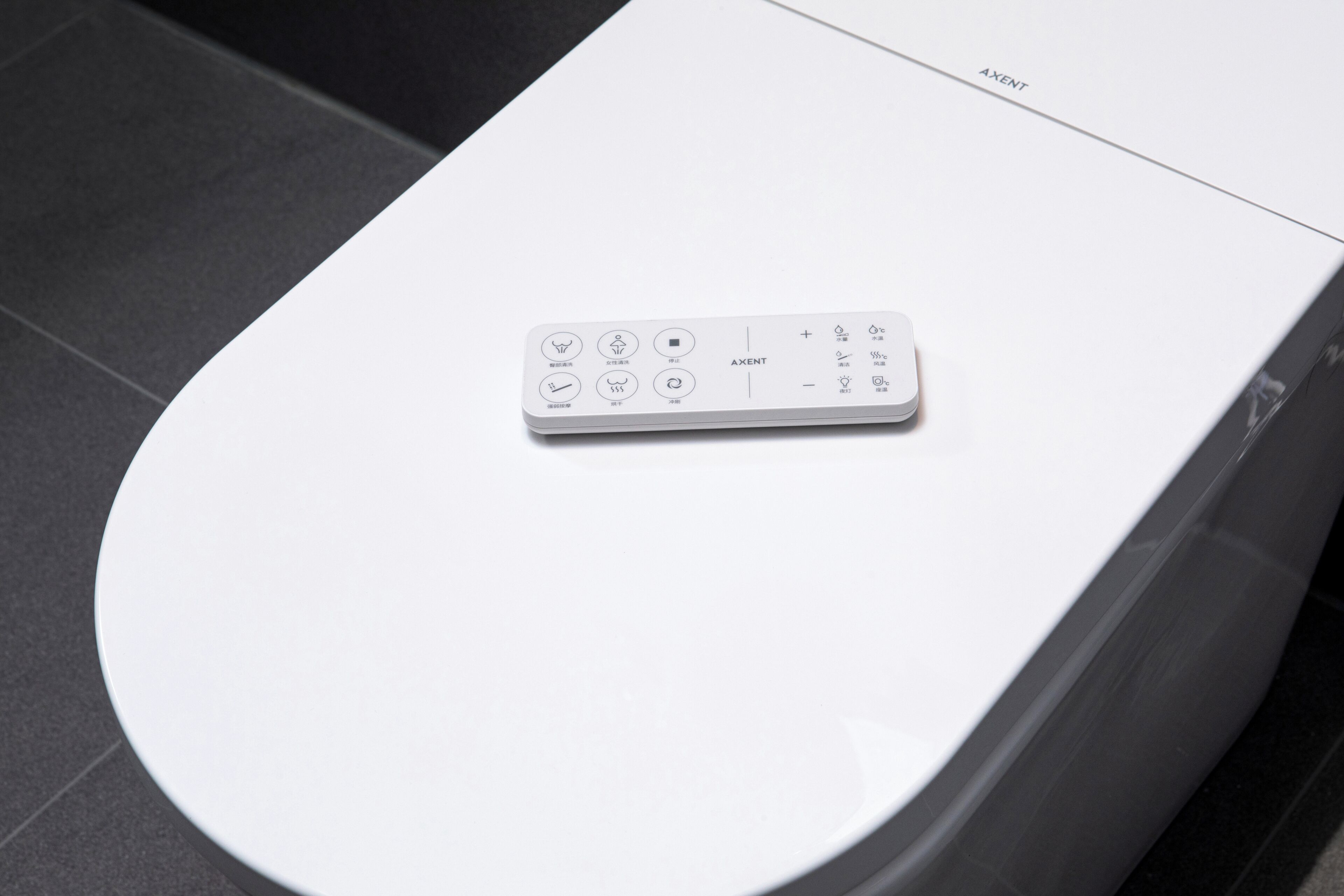 A remote control on a white surface, possibly a table or counter.