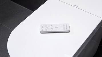 A remote control on a white surface, possibly a table or counter.