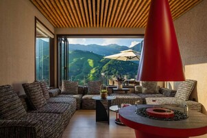 A modern lounge area with a view of green hills and mountains.