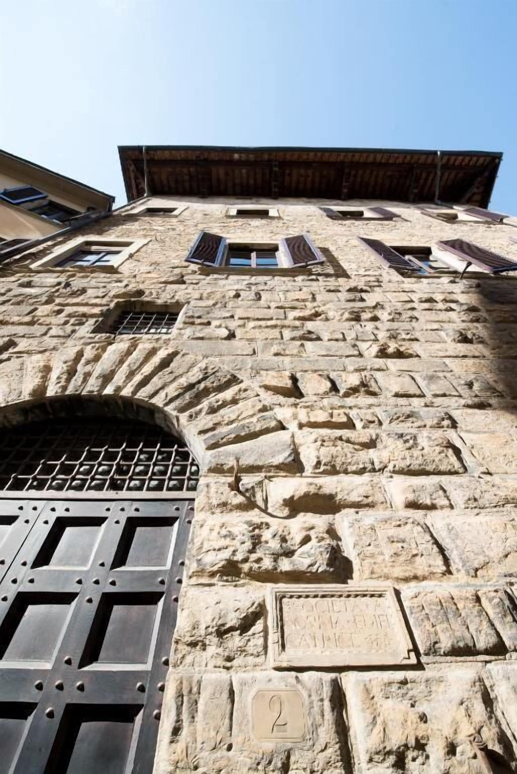 A stone building with a large arched entrance and a numbered plaque.