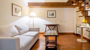 Un salon avec un canapé, une table et un escalier.