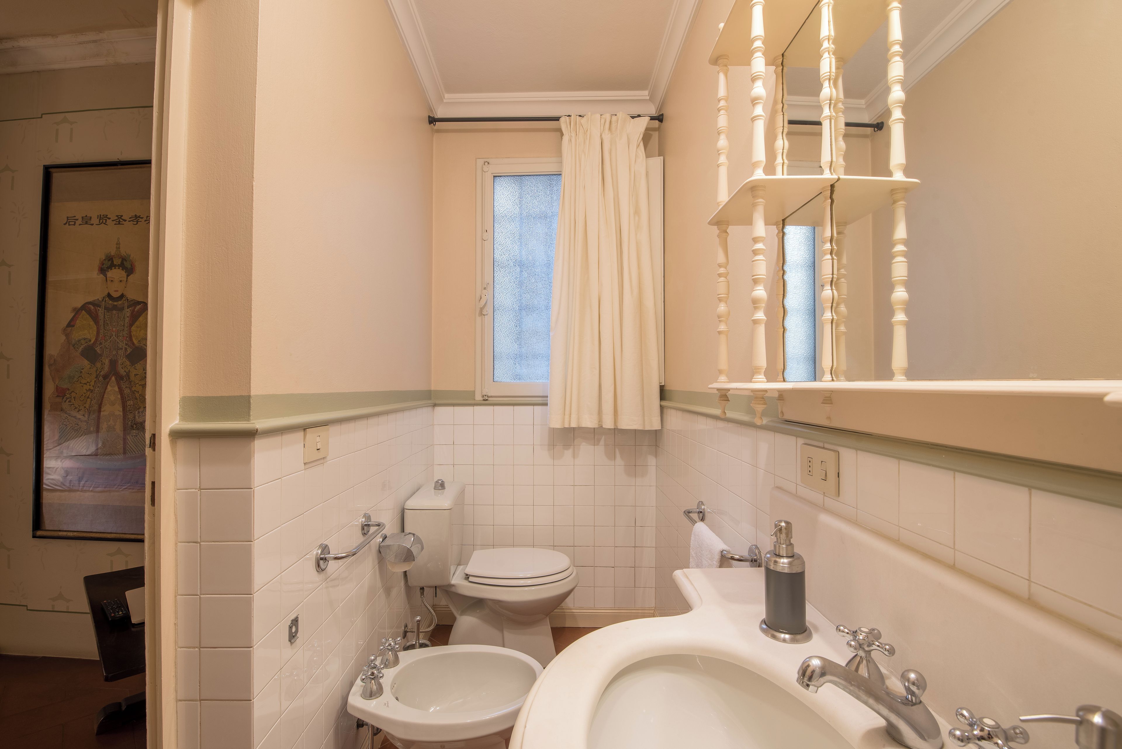 Ein Badezimmer mit Toilette, Bidet, Waschbecken und Spiegel.