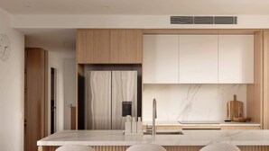 A modern kitchen with a central island, three bar stools, wooden cabinetry, and a marble backsplash. - The Lagoon, Main Beach (Main Beach)