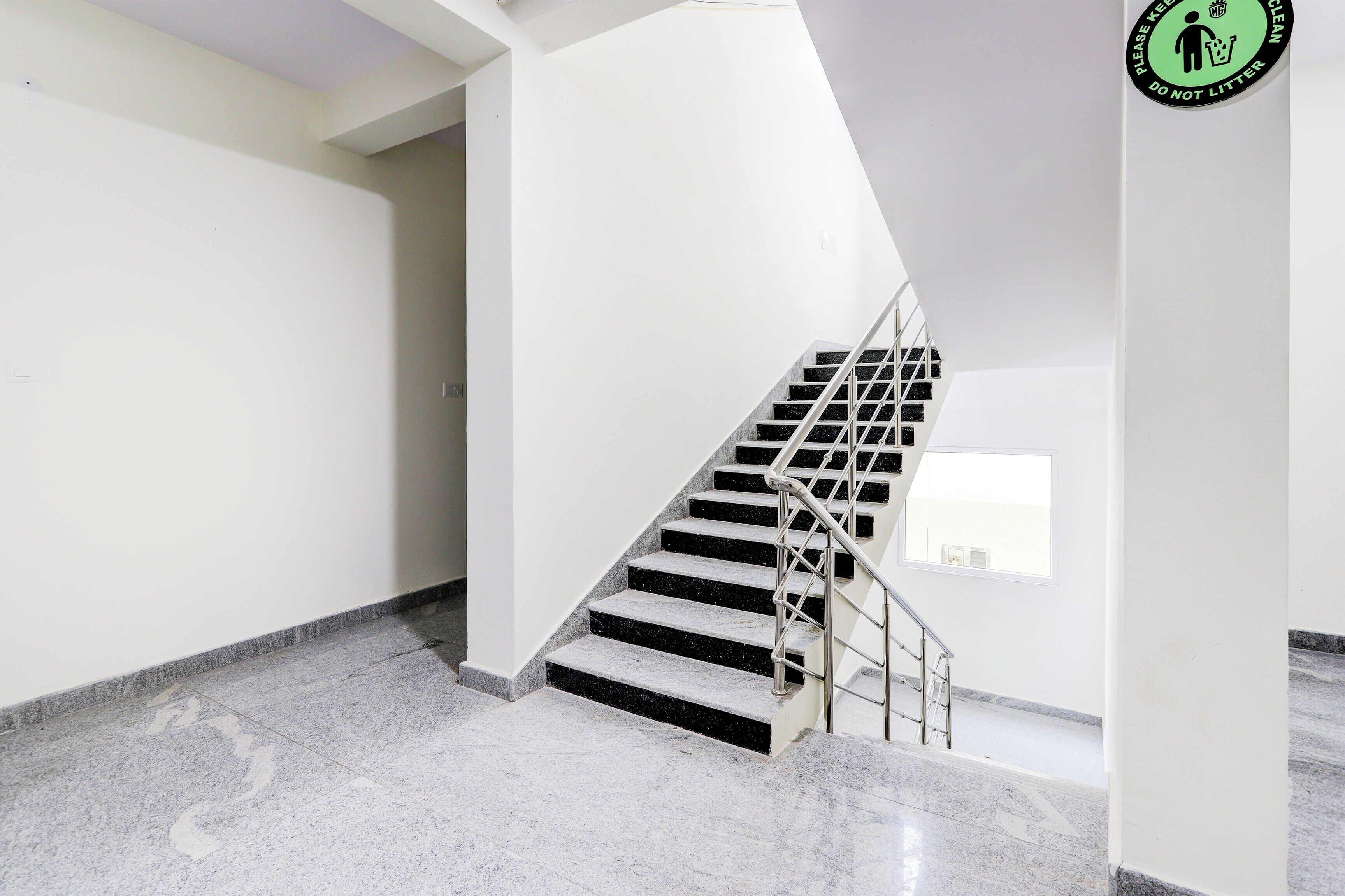 Eine Treppe mit Metallgeländern, die zu einer Zwischenebene führt.