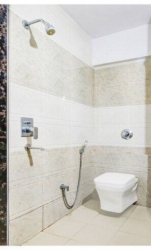 Un baño con ducha, inodoro y grifo de pared.