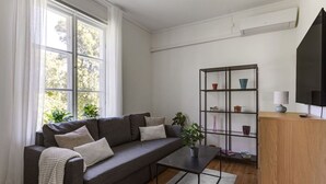 A modern living room with a grey sofa, a coffee table, a bookshelf, and a TV. - Peaceful Stay near Uppsala - Near Forests & Nature (Österbybruk)