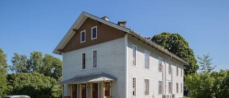 A two-story house with a porch, a garage, and a driveway.
