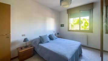 Ein Schlafzimmer mit einem Bett, Nachttischlampen, einem Fenster und einer Heizung.