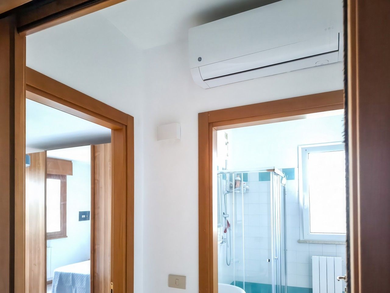Un bagno con doccia, una finestra e un condizionatore d'aria.