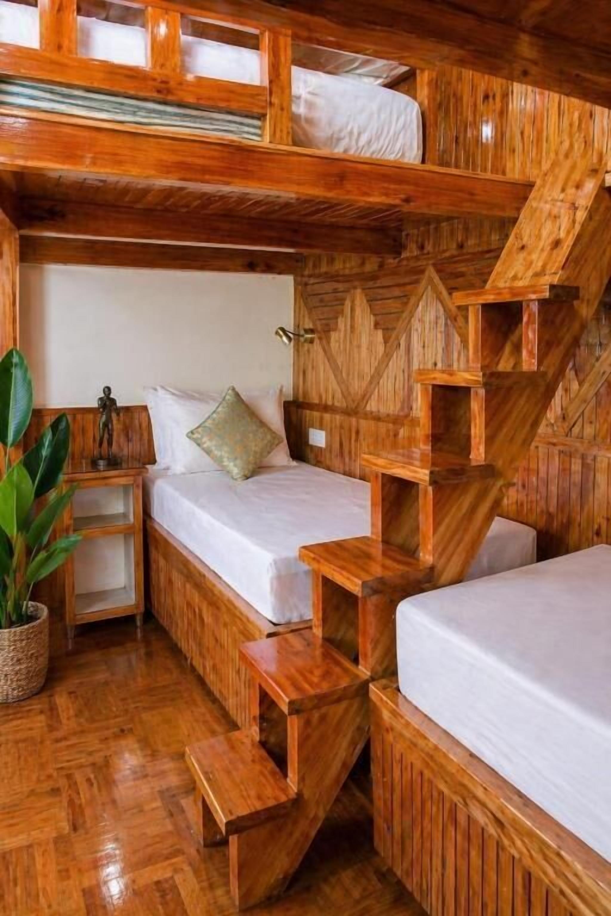 Ein Zimmer mit einem hölzernen Etagenbett und einer Treppe.