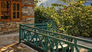 A stone building with a balcony and a view of mountains.