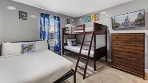 A bedroom with bunk beds, a dresser, and a painting of a castle. - 1120 Challenge Drive (Davenport)