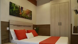 Een slaapkamer met een bed, nachtkastjes, een kledingkast en een schilderij aan de muur.