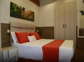 Ein Schlafzimmer mit einem Bett, Nachttischen, einem Kleiderschrank und einem Bild an der Wand.