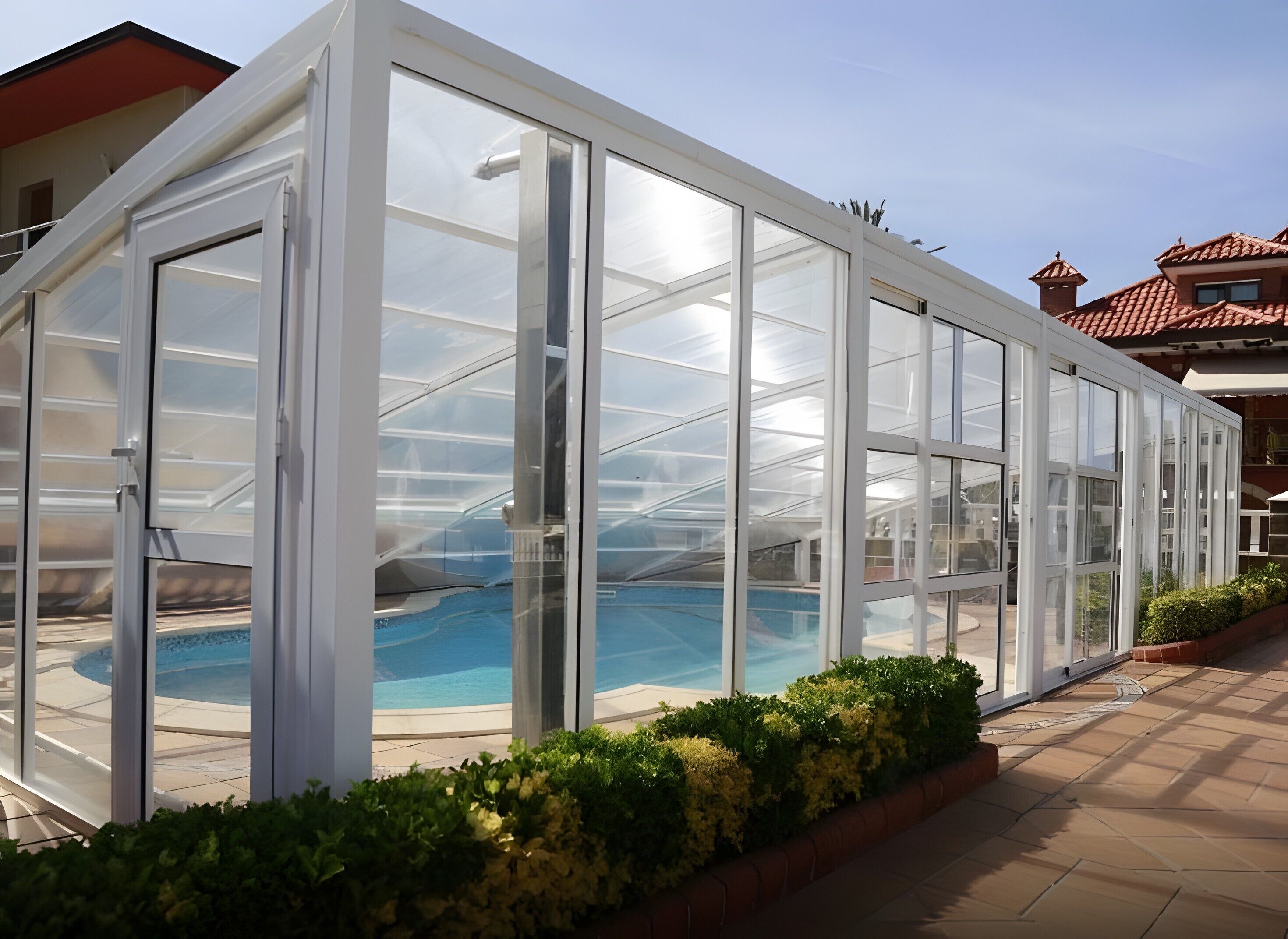 A glass-enclosed pool area with a clear view of the pool and surrounding greenery.