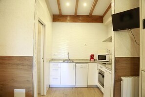 A compact kitchen with white cabinets, a dishwasher, a microwave, and a stove. - Studio with Terrace and Pool (Miengo)