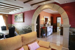 A hotel lobby with a reception desk, a dining area, and a seating area with a sofa and a patterned cushion. - Casa La Arena with pool (Miengo)