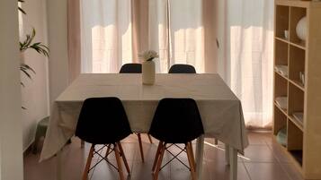 Een eetgedeelte met een tafel, stoelen en een bloevas.