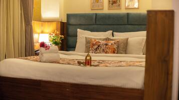 A hotel room with a bed, a nightstand, a lamp, and a vase with flowers.
