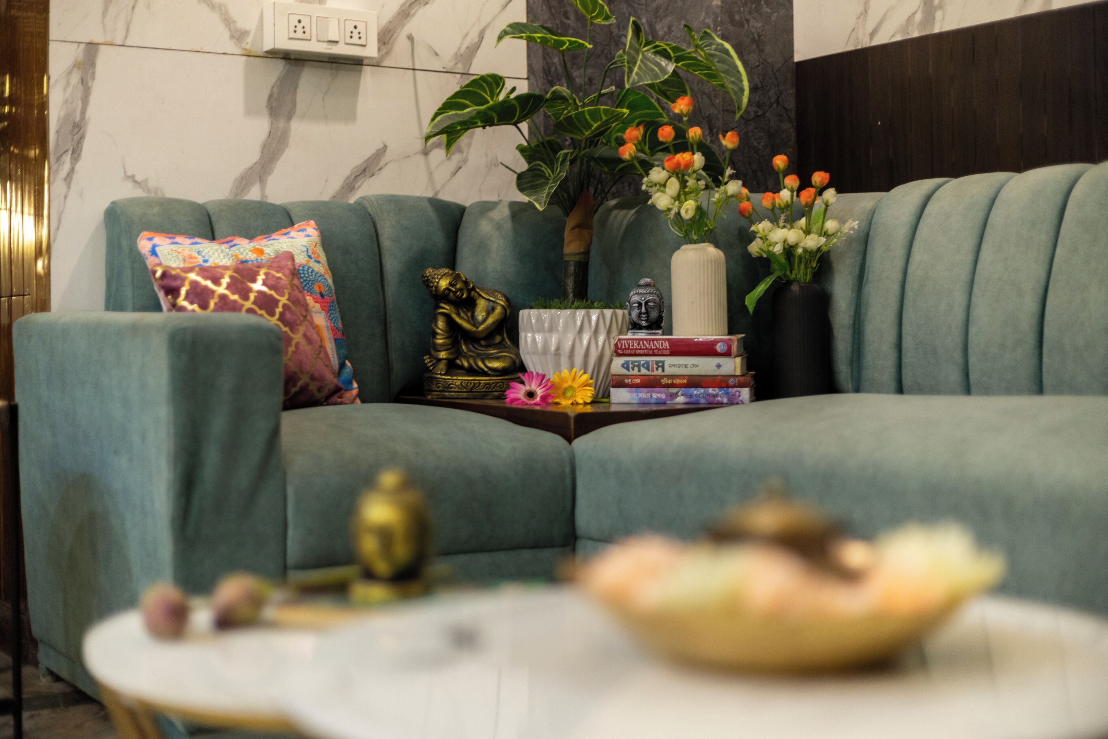 Ein Wohnzimmer mit einer Couch, einem Couchtisch und einer Buddha-Statue.