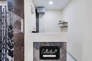 Un interior limpio y moderno con pared de mármol, un purificador de aire instalado y un letrero que indica 'Collection Company-Serviced'.
