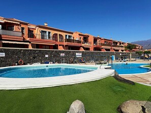 A hotel with a swimming pool, outdoor seating, and a mountain view. - Atlantico Apartment: Air Conditioning, Swimming Pool (Santa Cruz de Tenerife)