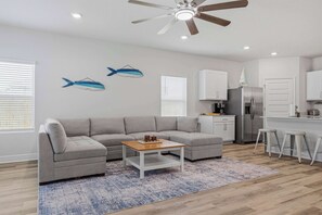 A modern living room with a grey sectional sofa, a wooden coffee table, and a ceiling fan. - Home with Pickleball Courts, Wifi & Beach Essentials (Navarre)