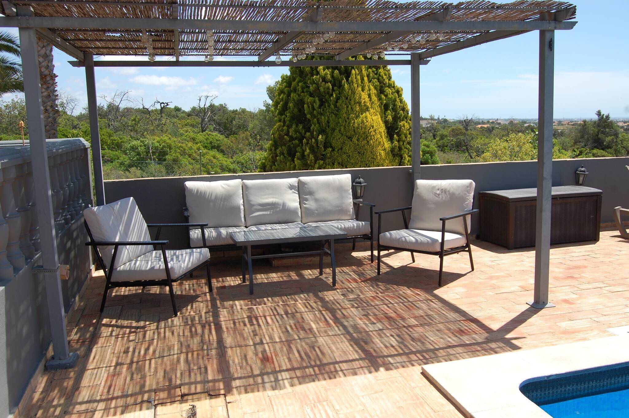A covered outdoor seating area with a pool.