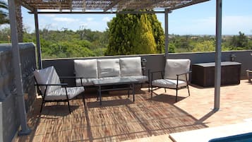 A covered outdoor seating area with a pool.