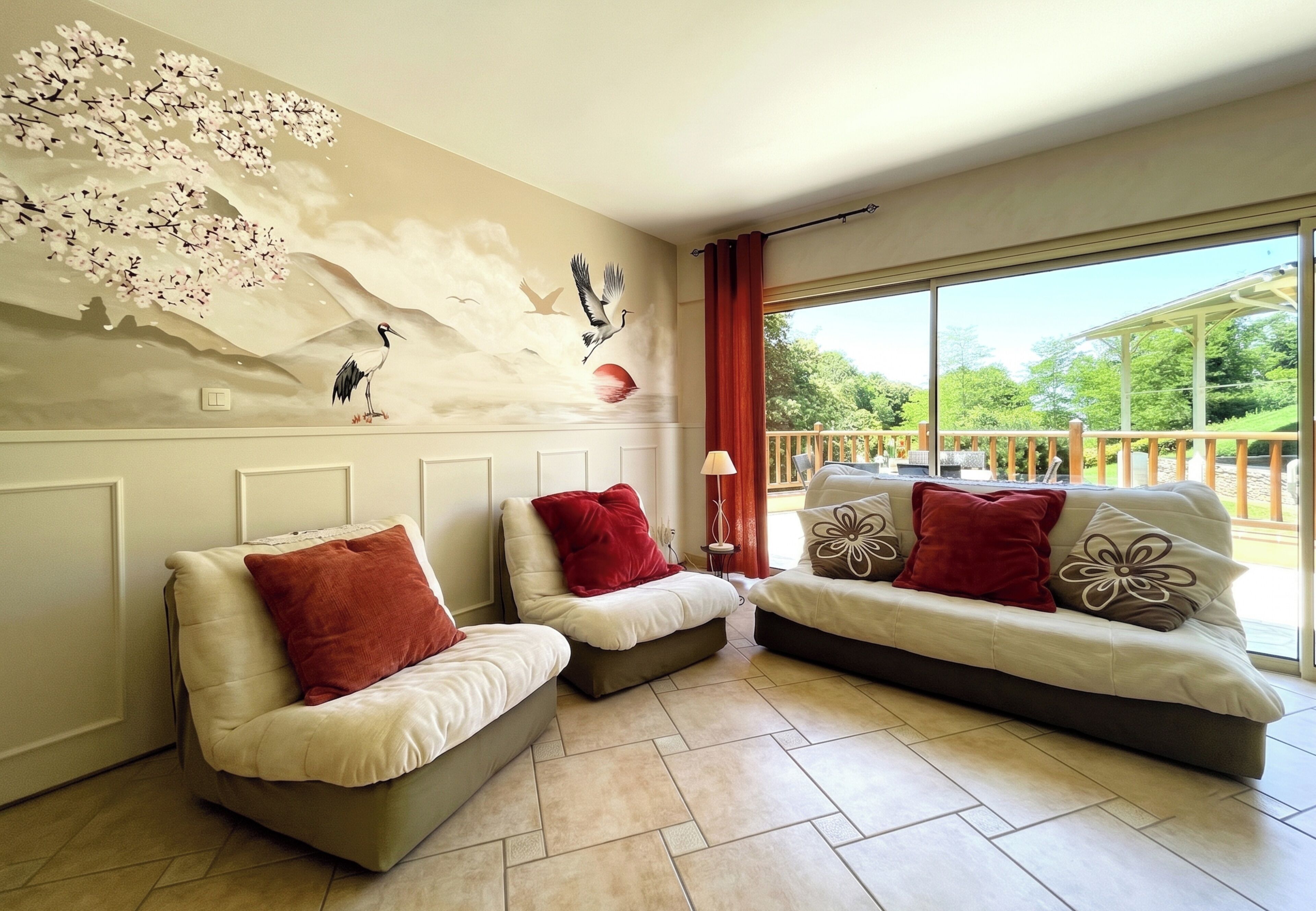 A room with two sofas, a wall mural, and a large window with a view of greenery.