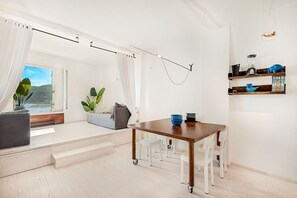 A modern kitchen with a wooden table, white chairs, and a view of the outdoors. - [LaFinestraSulMare] Parking+A/C/Portovenere/5Terre (Portovenere)