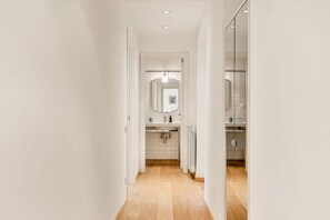 A hallway leading to a bathroom with a mirror, sink, and shower. - [Atto primo]Central area-Near the station (La Spezia)