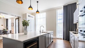 A modern kitchen with a central island, built-in oven, and stainless steel appliances. - Fields in Frame at No. 64 (London)