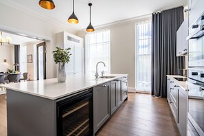 A modern kitchen with a central island, built-in oven, and stainless steel appliances. - Fields in Frame at No. 64 (London)