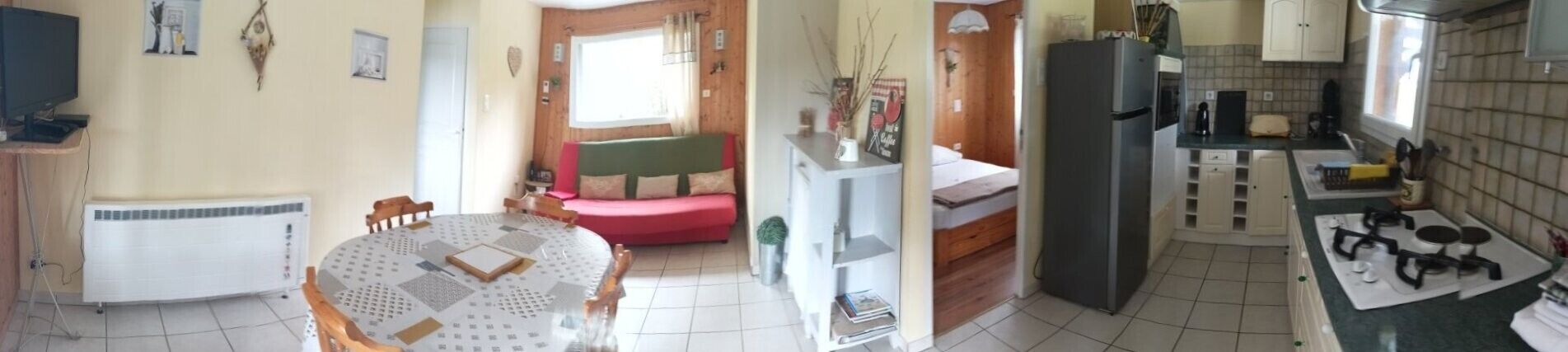 A compact living space with a dining area, a kitchenette, and a small seating area.