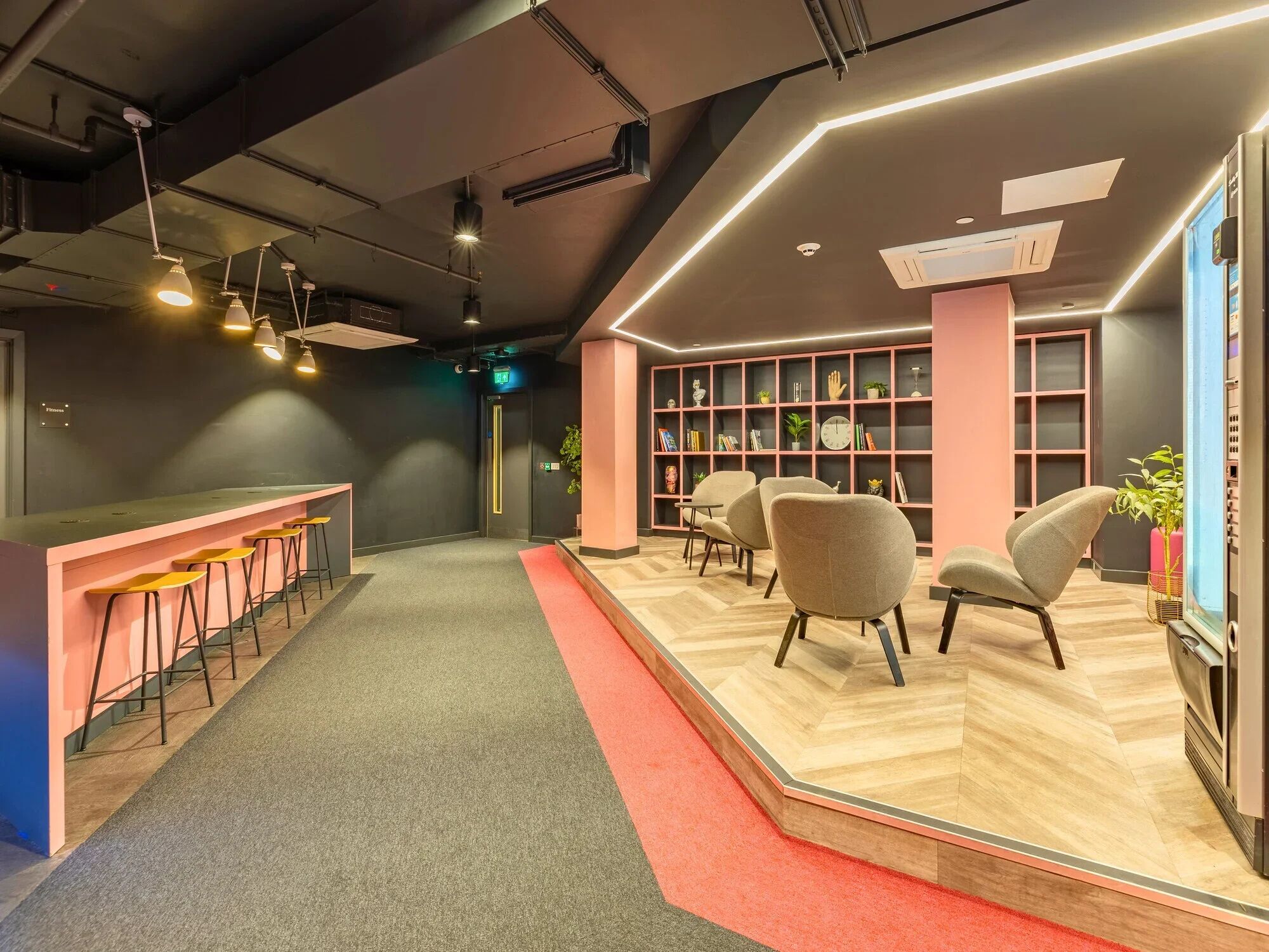 A modern interior with a bar area, seating, and a bookshelf.